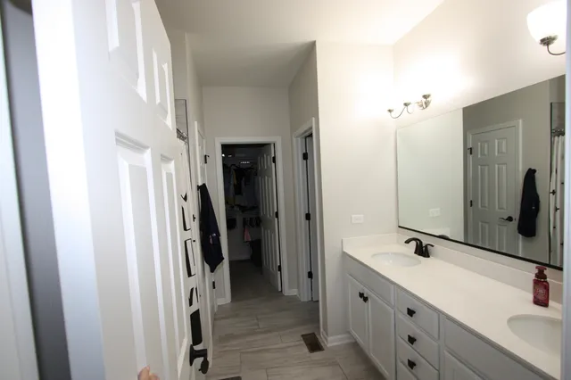 a bathroom with a double vanity sink and mirror