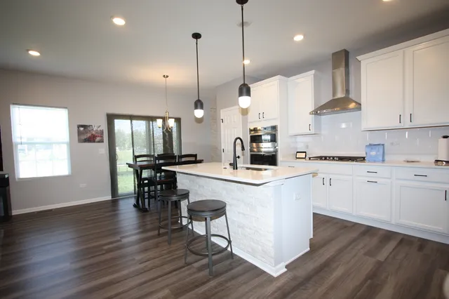a kitchen with kitchen island granite countertop a sink a counter space appliances and a center island