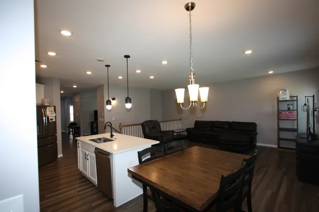 a kitchen with a dining table chairs and a chandelier