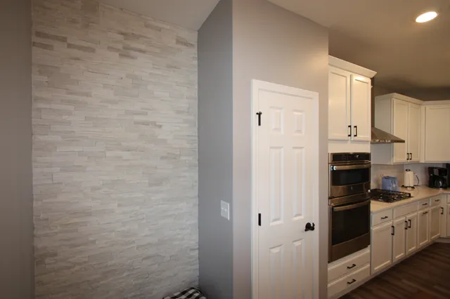 a kitchen with a refrigerator stove and white cabinets