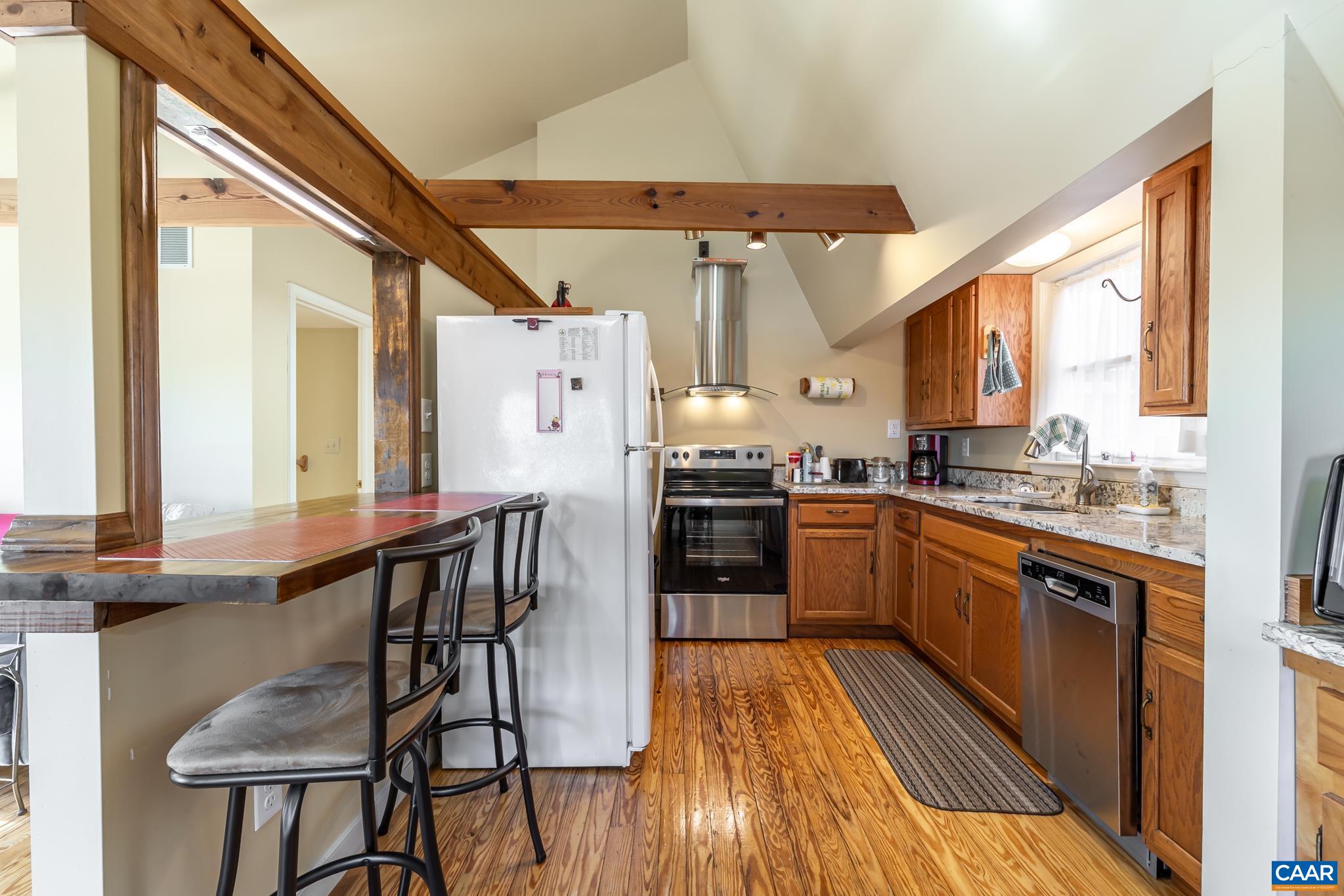 1022 Turkey Ridge Road Stanardsville, VA 22973 - Photo 39 of 74 a kitchen with granite countertop a stove a sink and wooden cabinets