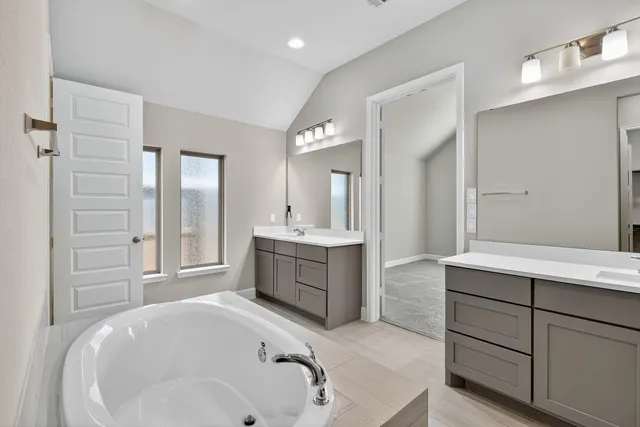 a spacious bathroom with a tub sink and mirror