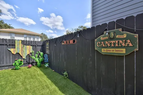 a view of backyard with a table and chairs and potted plants