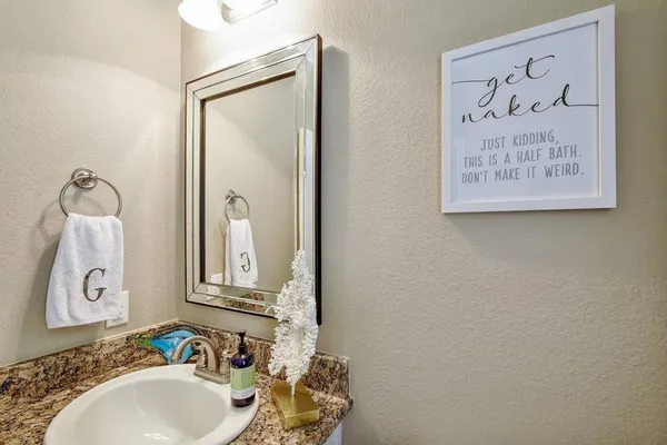 a kitchen with stainless steel appliances granite countertop a refrigerator a stove top oven a sink dishwasher and white cabinets with wooden floor