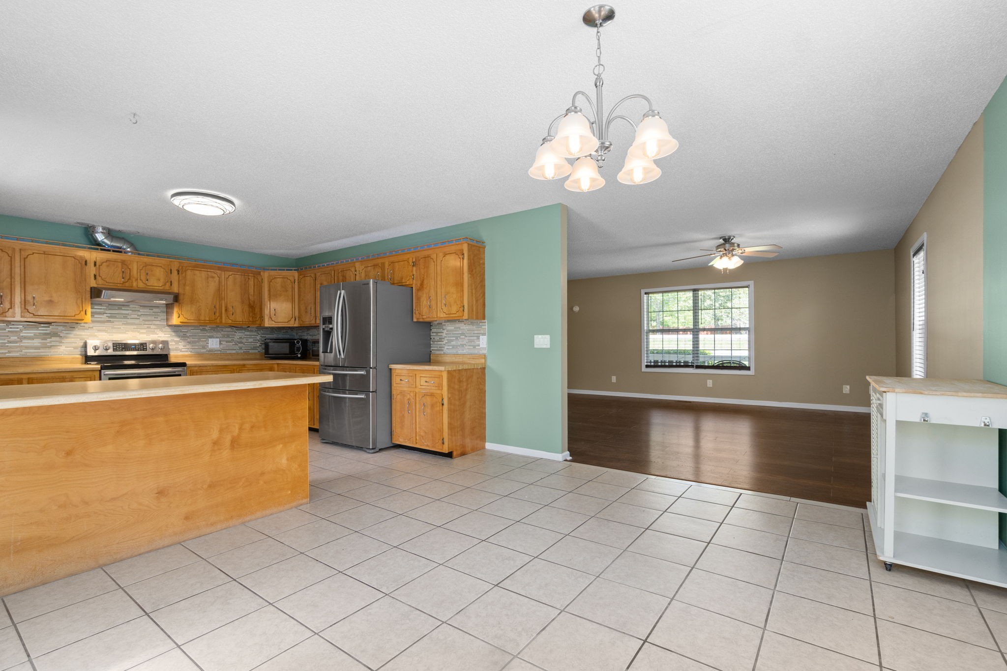 3315 Lylewood Road Woodlawn, TN 37191 - Photo 11 of 39 a large kitchen with cabinets a sink a window and stainless steel appliances