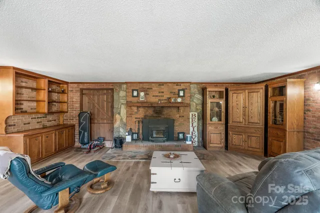 a living room with furniture a flat screen tv and a floor to ceiling window