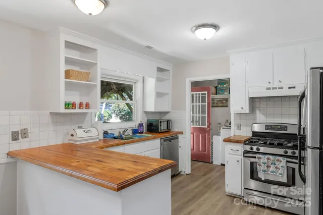 a kitchen with stainless steel appliances granite countertop a stove refrigerator sink and cabinets