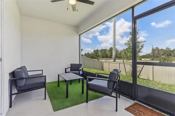a living room with furniture and a floor to ceiling window