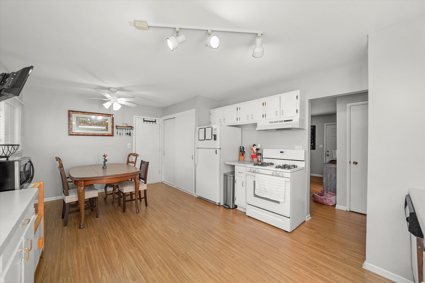 406 Cahill Road Streamwood, IL 60107 - Photo 8 of 22 a kitchen with stainless steel appliances a dining table chairs and wooden floor