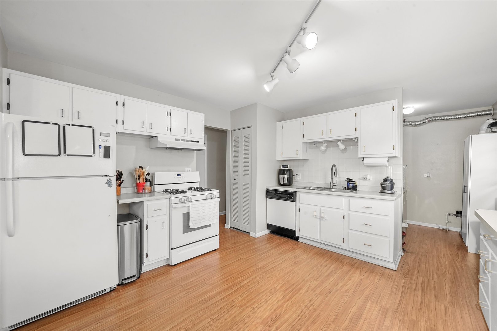 406 Cahill Road Streamwood, IL 60107 - Photo 9 of 22 a kitchen with white cabinets and white appliances