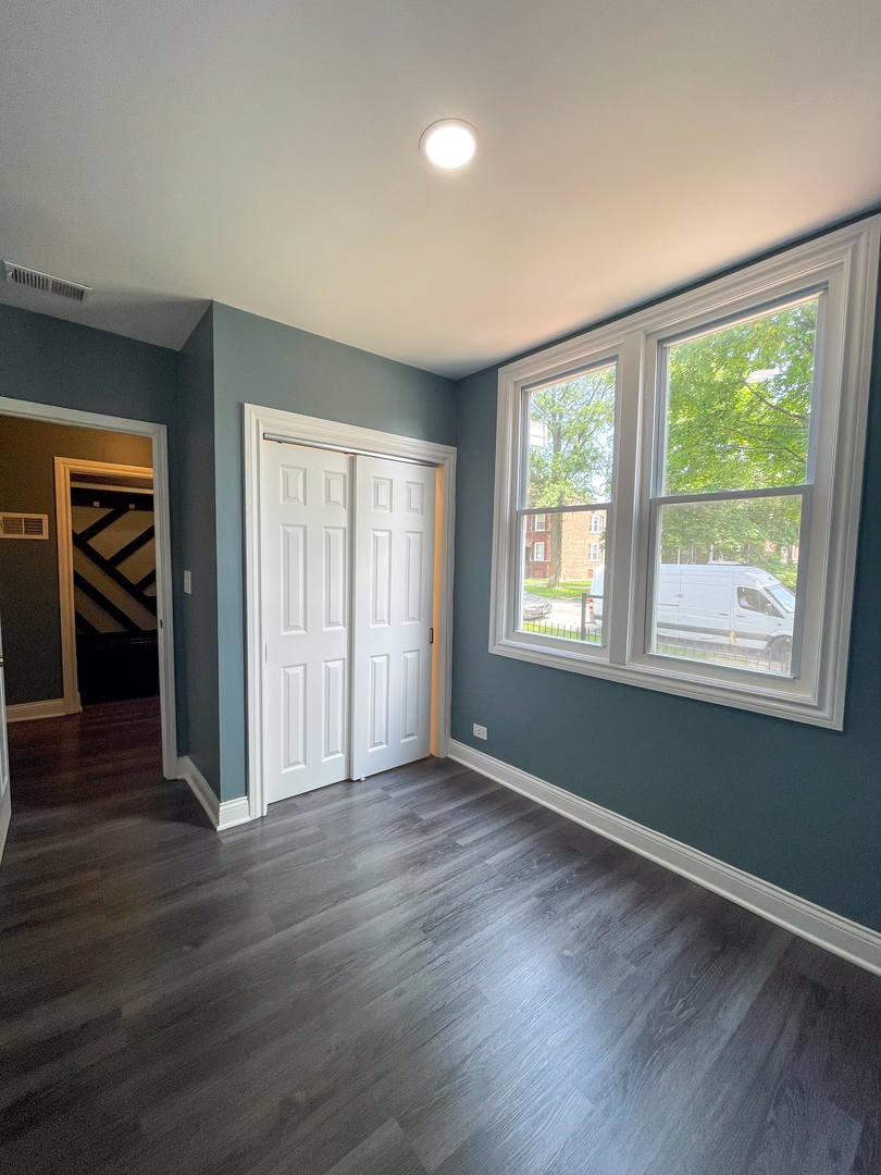 7046 South Wabash Avenue Chicago, IL 60637 - Photo 15 of 41 a view of an empty room with wooden floor and a window