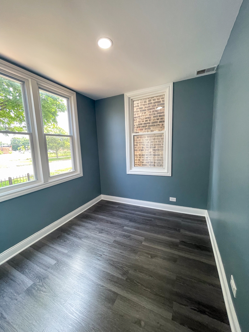 7046 South Wabash Avenue Chicago, IL 60637 - Photo 16 of 41 a view of an empty room with wooden floor and a window