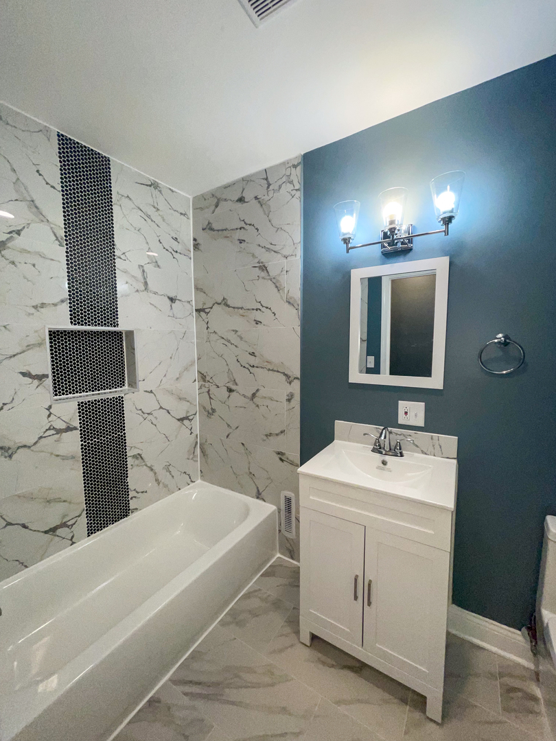 7046 South Wabash Avenue Chicago, IL 60637 - Photo 23 of 41 a bathroom with a sink a large mirror and a bathtub