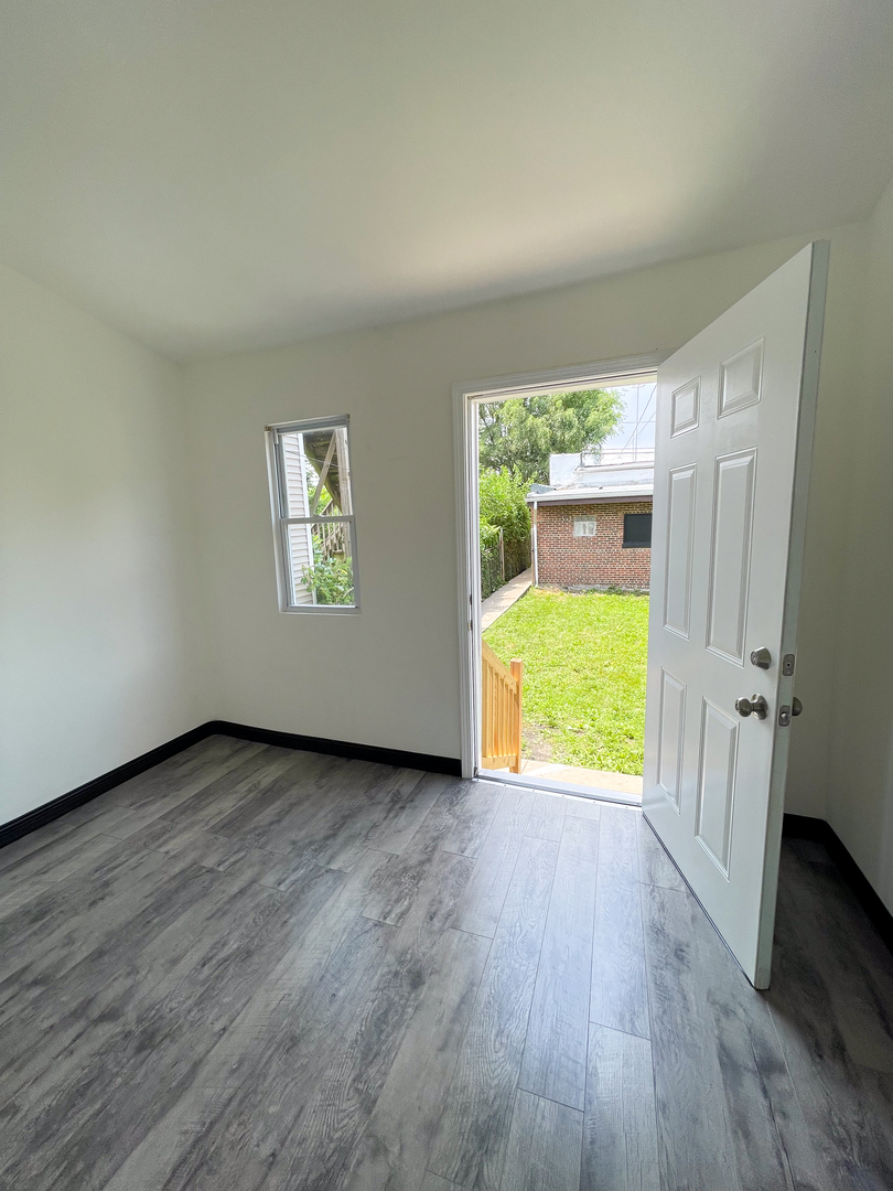 7046 South Wabash Avenue Chicago, IL 60637 - Photo 29 of 41 an empty room with wooden floor and a window