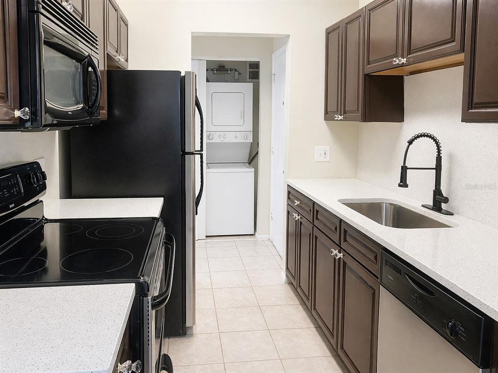 1695 Lee Road, Unit C206 Winter Park, FL 32789 - Photo 6 of 18 a kitchen with stainless steel appliances a stove microwave and a sink