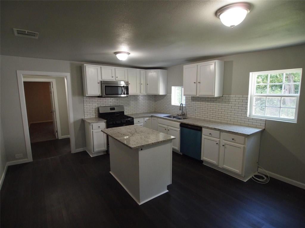 502 South Rusk Street Sherman, TX 75090 - Photo 3 of 15 a kitchen with granite countertop a sink cabinets and stainless steel appliances