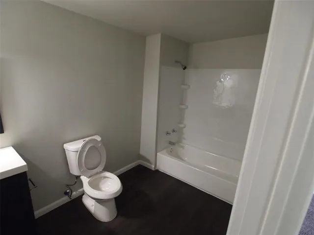 a white toilet sitting next to a bath tub