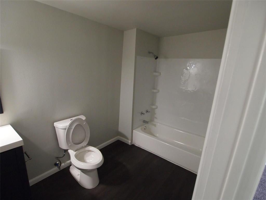 502 South Rusk Street Sherman, TX 75090 - Photo 10 of 15 a white toilet sitting next to a bath tub