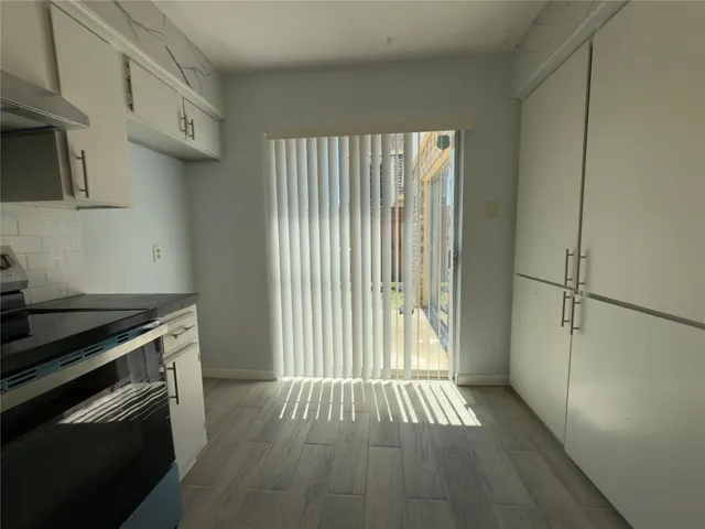 a view of an empty room with a fireplace and a window