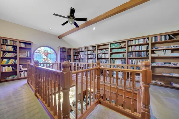 a view of staircase with lots of frames and white walls
