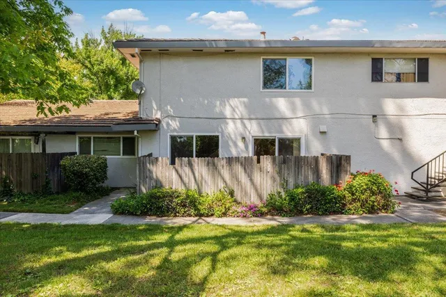 a view of a white house with a yard and plants