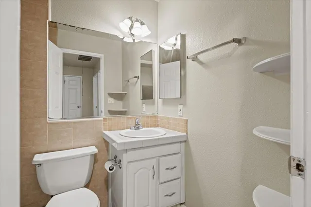 a bathroom with a toilet sink and mirror