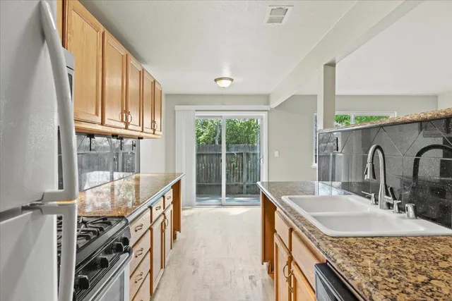 a bathroom with a granite countertop sink a mirror a bathtub and next to a window