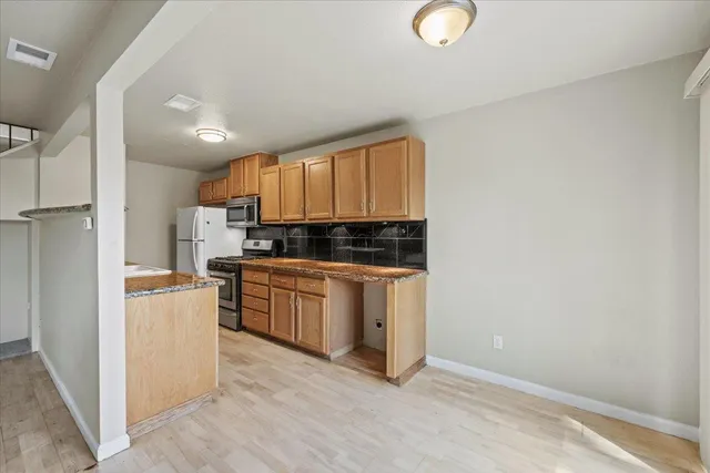 a kitchen with a refrigerator and a stove top oven