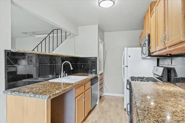 a kitchen with kitchen island granite countertop a sink and refrigerator