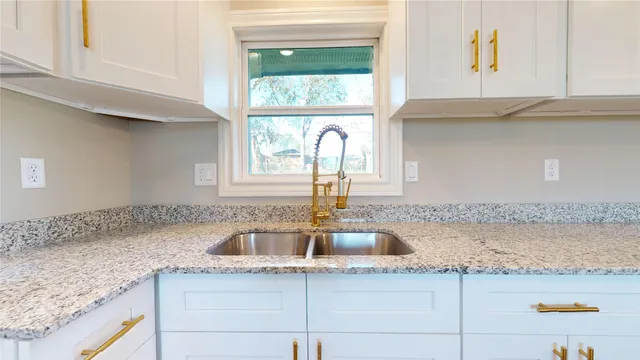 a kitchen with granite countertop a sink and a window
