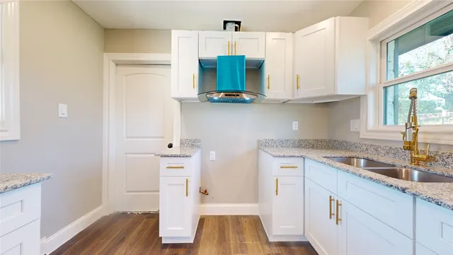 a kitchen with granite countertop white cabinets and white appliances