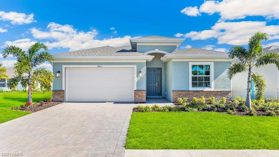 17833 Shade Tree Loop Punta Gorda, FL 33982 - Photo 1 of 39 Model photo - View of front of property with stone siding, stucco siding, decorative driveway, a front yard, and a garage