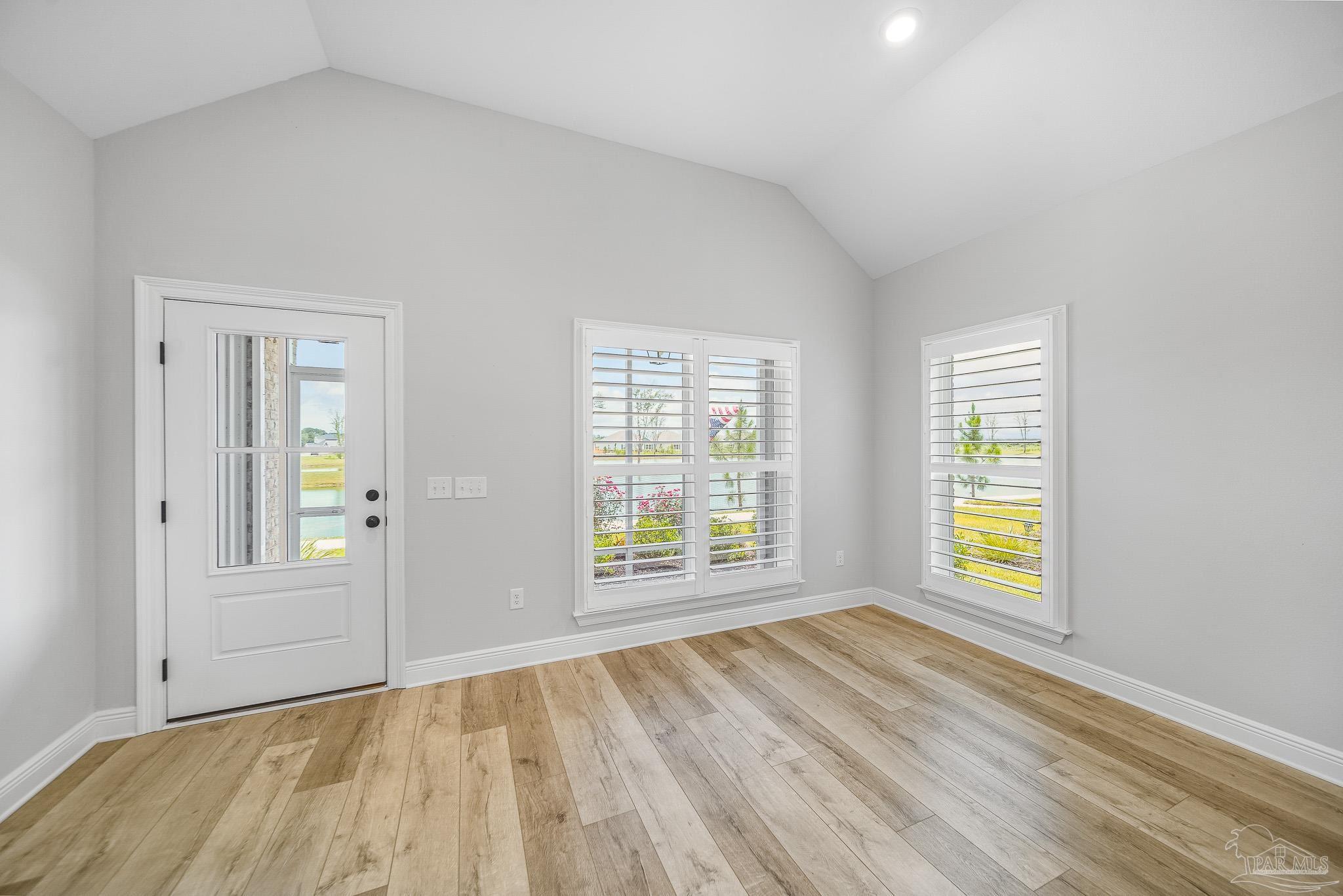 8977 Eureka Street Milton, FL 32583 - Photo 13 of 44 an empty room with wooden floor and windows