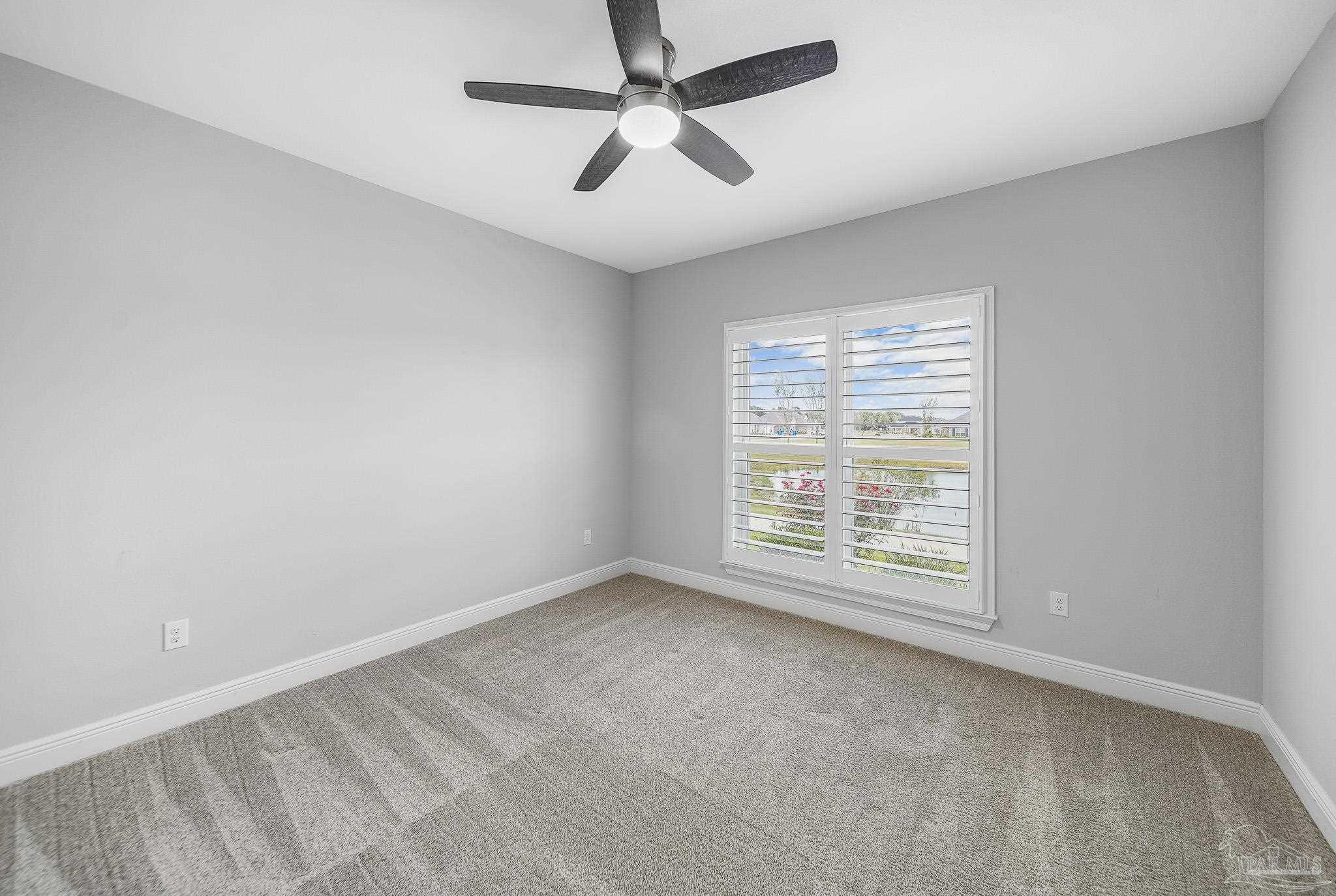 8977 Eureka Street Milton, FL 32583 - Photo 16 of 44 an empty room with a window and a fan