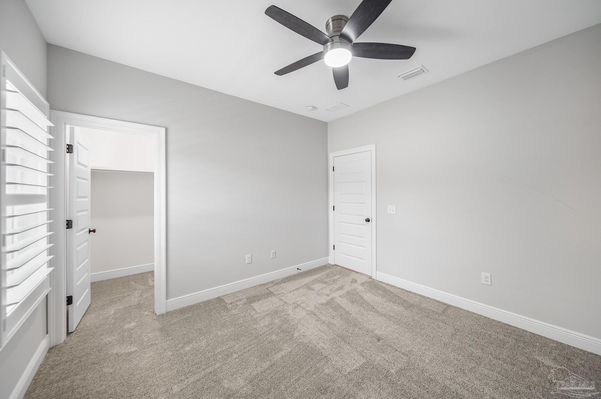 8977 Eureka Street Milton, FL 32583 - Photo 19 of 44 an empty room with a ceiling fan and a bathroom