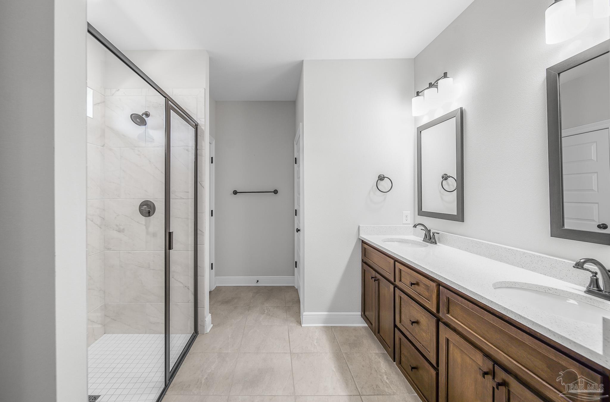 8977 Eureka Street Milton, FL 32583 - Photo 26 of 44 a spacious bathroom with a double vanity sink mirror double and shower