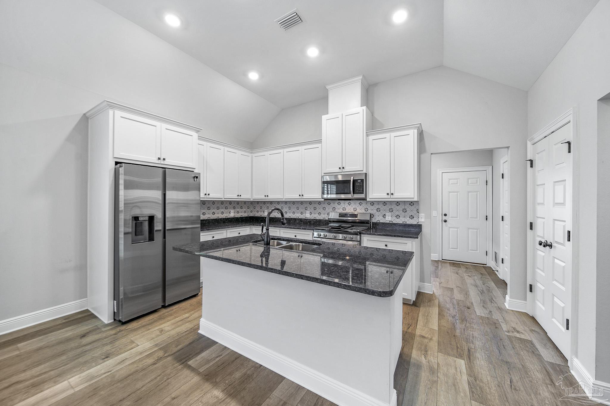 8977 Eureka Street Milton, FL 32583 - Photo 3 of 44 a kitchen with stainless steel appliances granite countertop a refrigerator and a stove