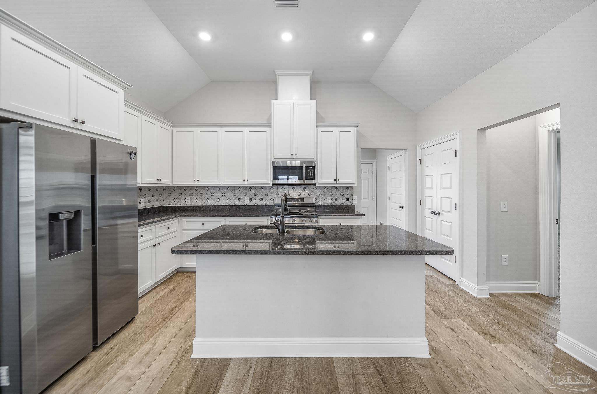 8977 Eureka Street Milton, FL 32583 - Photo 4 of 44 a kitchen with stainless steel appliances granite countertop a sink stove and refrigerator
