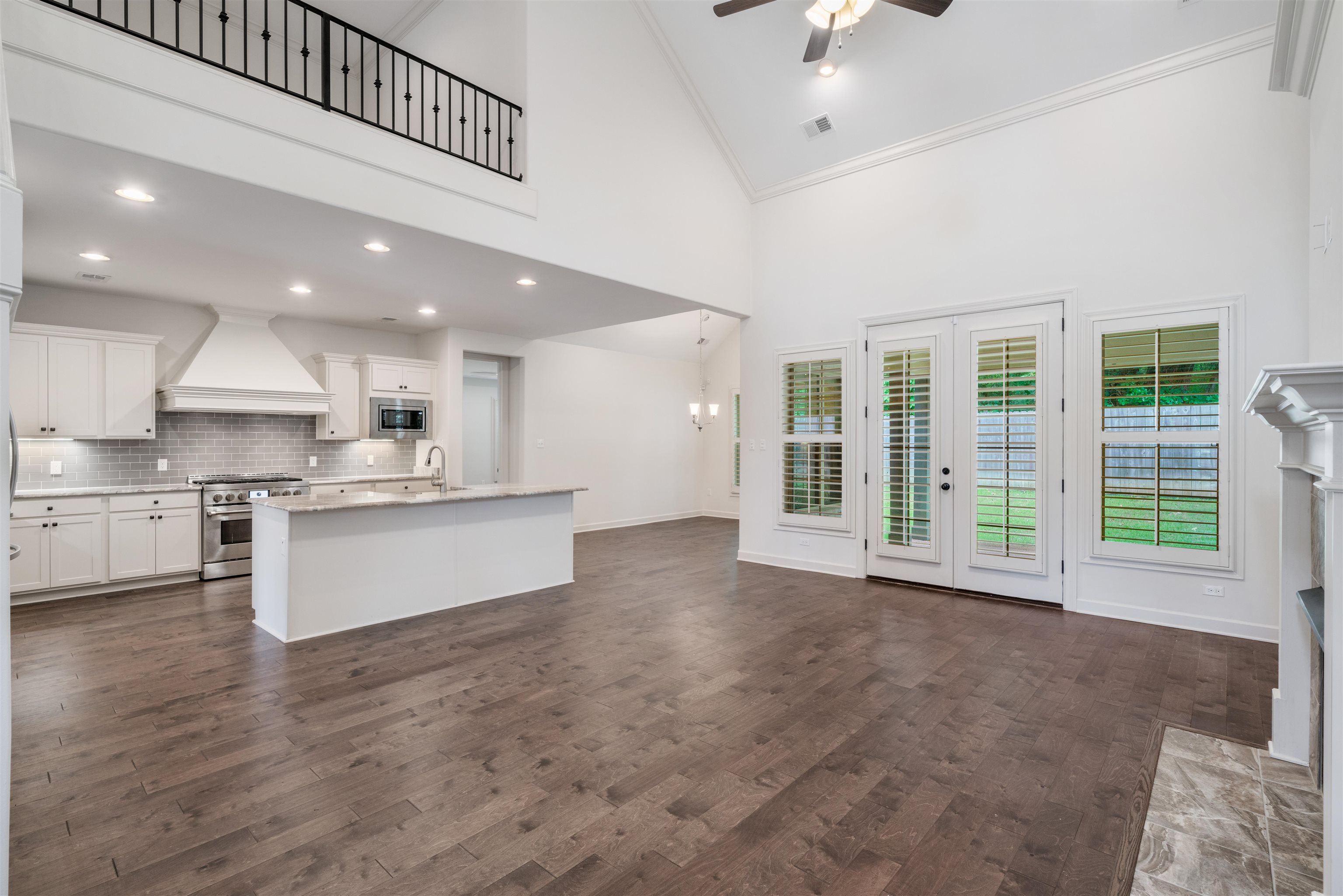 4713 Emmas Circle West Collierville, TN 38017 - Photo 5 of 28 a large kitchen with stainless steel appliances kitchen island a large counter top a stove a refrigerator cabinets and living room view