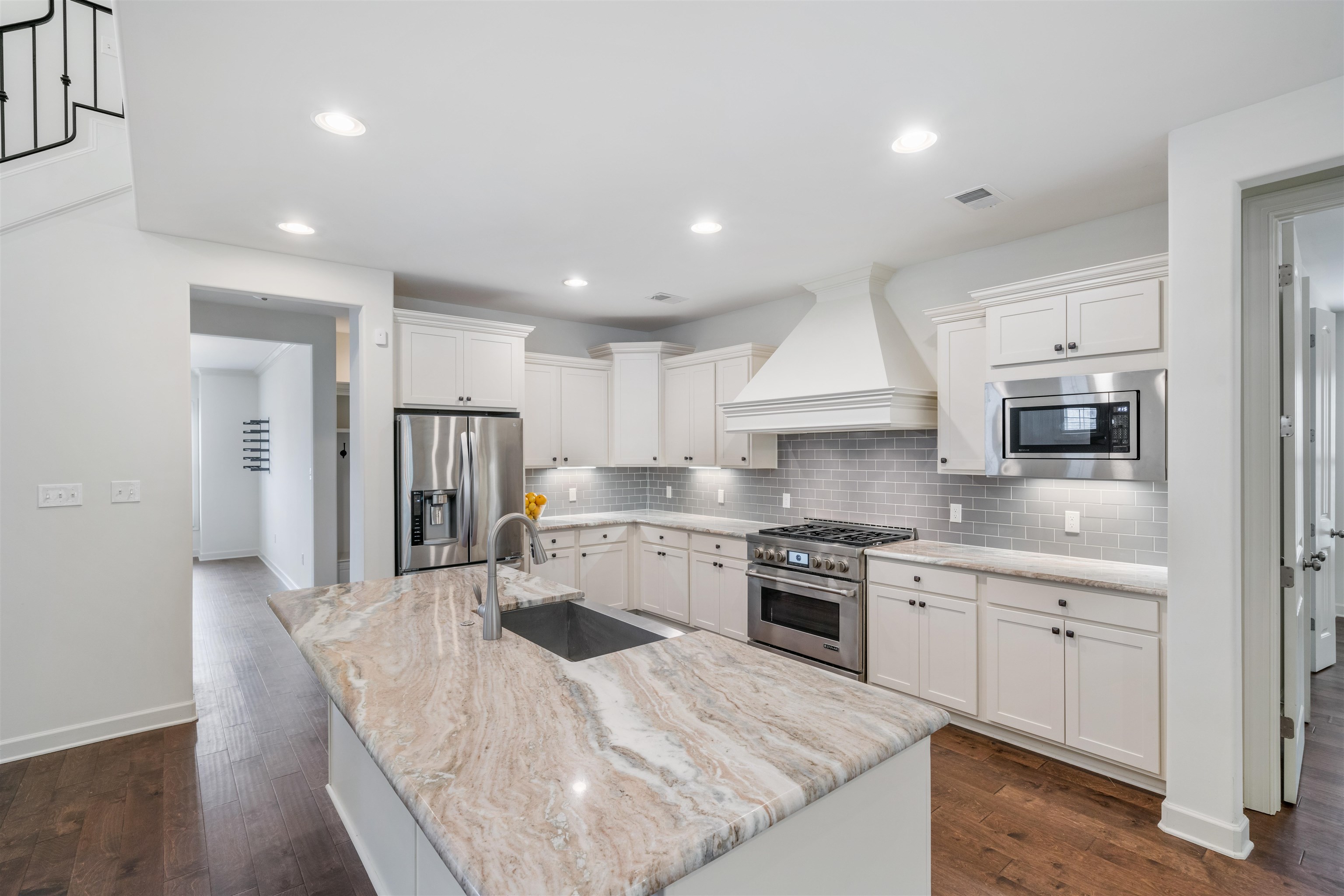 4713 Emmas Circle West Collierville, TN 38017 - Photo 8 of 28 a kitchen with stainless steel appliances granite countertop a stove top oven a sink dishwasher and a refrigerator with wooden floor