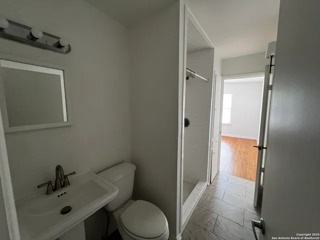 a bathroom with a sink toilet and shower