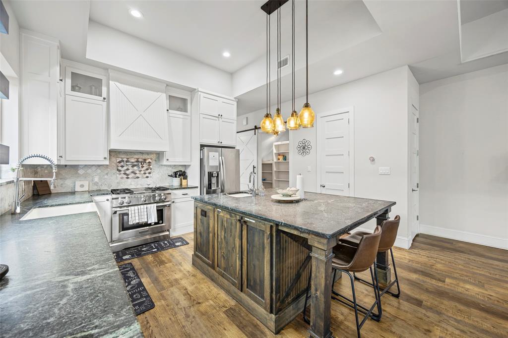 2011 North Prairie Avenue, Unit 2011 Dallas, TX 75204 - Photo 12 of 39 a kitchen with a table chairs stove and cabinets