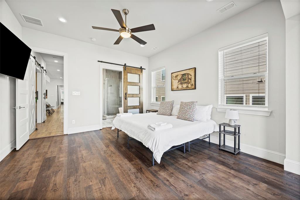 2011 North Prairie Avenue, Unit 2011 Dallas, TX 75204 - Photo 21 of 39 a spacious bedroom with a bed and a flat screen tv