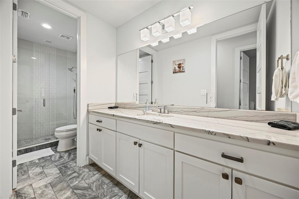 2011 North Prairie Avenue, Unit 2011 Dallas, TX 75204 - Photo 27 of 39 a bathroom with a granite countertop sink a toilet and a mirror