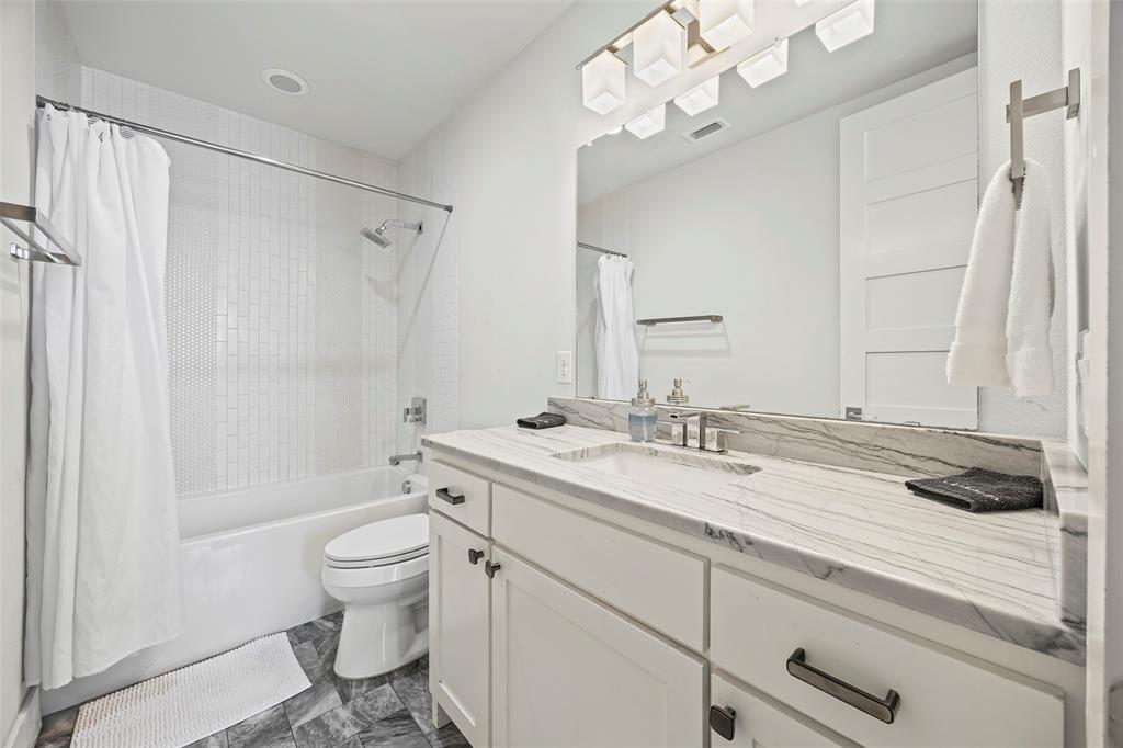 2011 North Prairie Avenue, Unit 2011 Dallas, TX 75204 - Photo 31 of 39 a bathroom with a granite countertop sink a toilet and a mirror