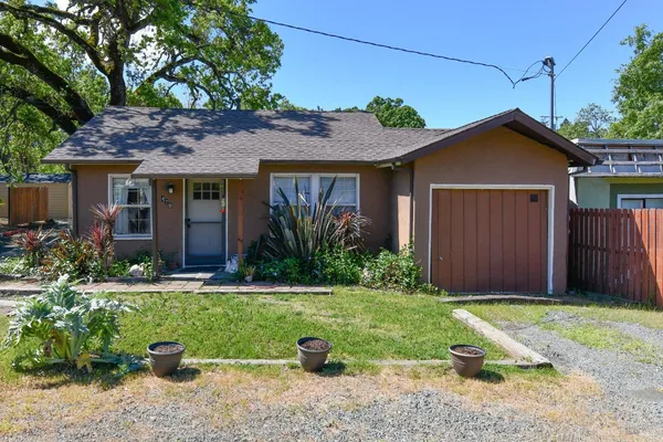 a front view of a house with a yard and potted plants