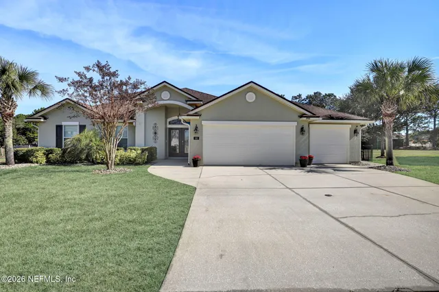 a front view of a house with a garden and trees