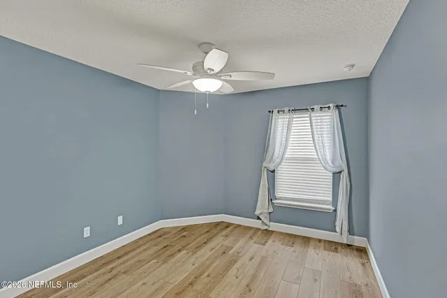 wooden floor in an empty room with a window