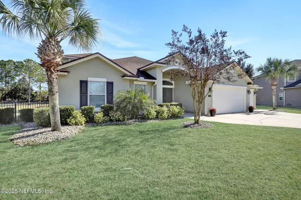 a front view of a house with a yard and lake view