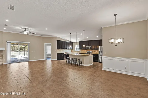 a large kitchen with kitchen island a chandelier stainless steel appliances cabinets and a counter top space